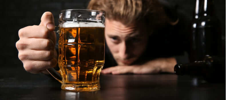 мужчина смотрит на кружку пива
